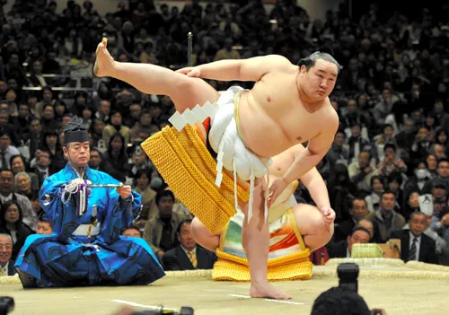 A retired professional sumo wrestler in traditional mawashi posing before a bout in Japan
